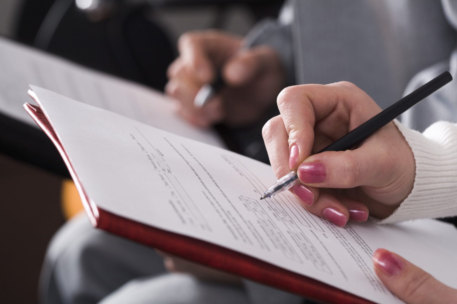 A person completing a written form